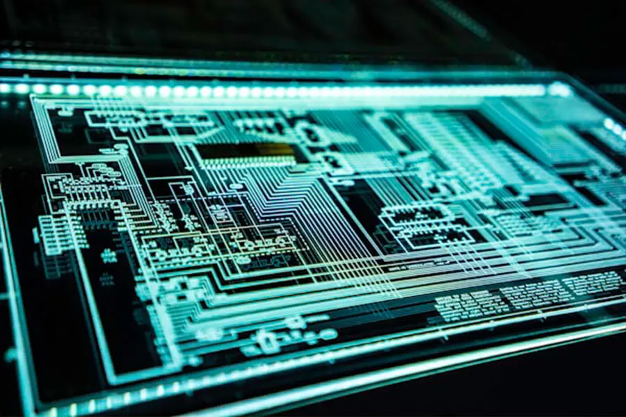 Close-up of a glowing circuit board with intricate blue-green patterns and lines on a dark background, conveying a futuristic and technological atmosphere.