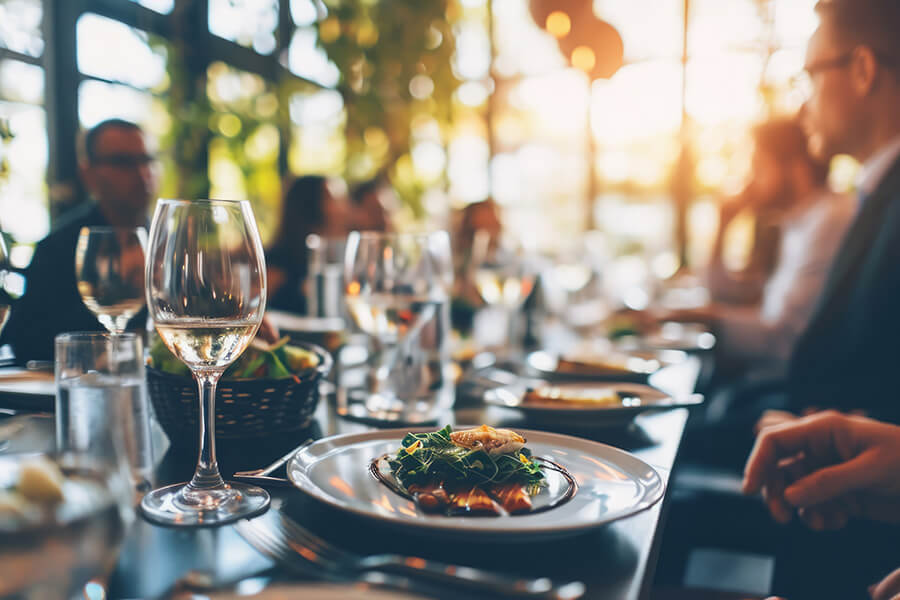 A restaurant table set with wine glasses, plates of food, and elegant tableware, creating a cozy dining atmosphere.